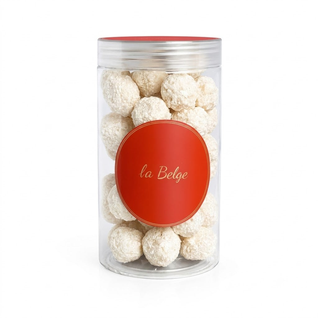 Glass jar filled with hazelnuts coated in white Belgian chocolate and coconut by La Belge.