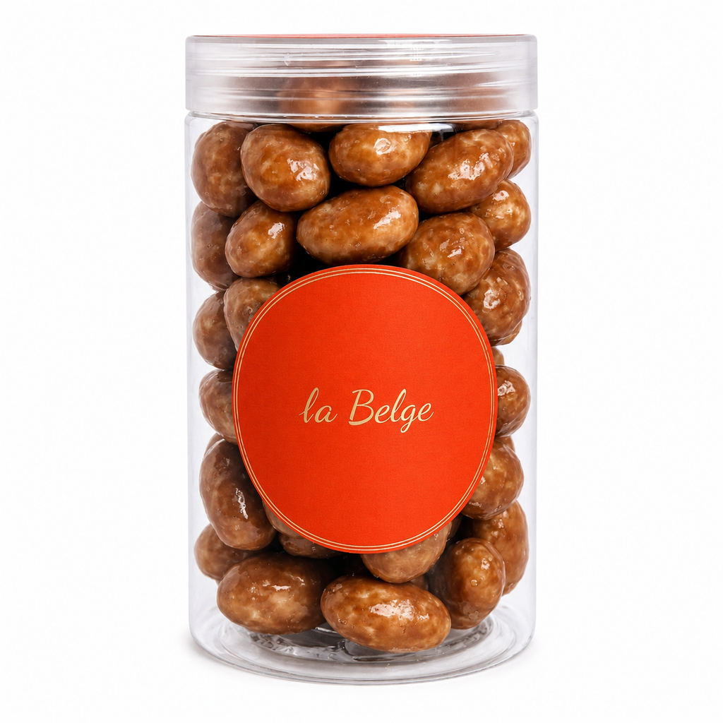 La Belge Caramel Almond in a premium clear cylinder filled with whole almonds coated in smooth caramel and fine Belgian chocolate.
